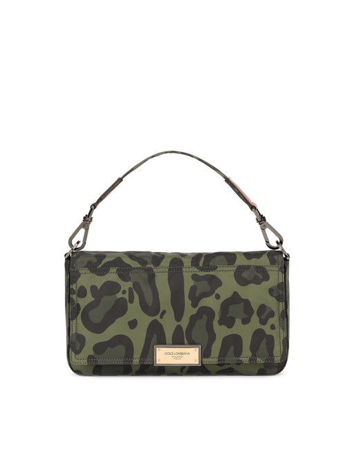 NYLON CROSSBODY BAG WITH LEOPARD PRINT AGAINST A GREEN BACKGROUND AND BRANDED PLATE