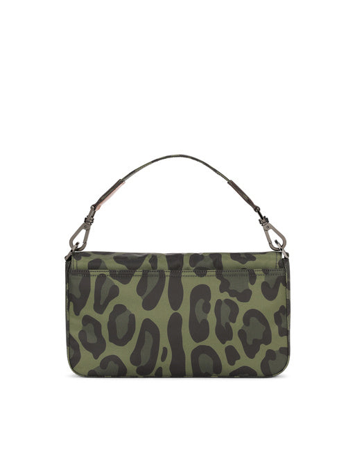 NYLON CROSSBODY BAG WITH LEOPARD PRINT AGAINST A GREEN BACKGROUND AND BRANDED PLATE