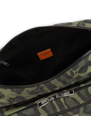 NYLON MESSENGER BAG WITH A LEOPARD PRINT AGAINST A GREEN BACKGROUND AND BRANDED PLATE