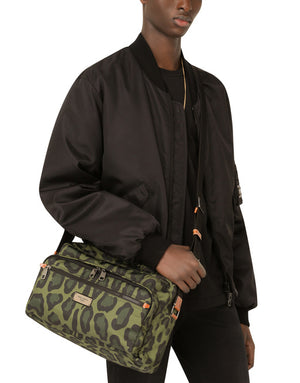 NYLON MESSENGER BAG WITH A LEOPARD PRINT AGAINST A GREEN BACKGROUND AND BRANDED PLATE