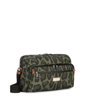 NYLON MESSENGER BAG WITH A LEOPARD PRINT AGAINST A GREEN BACKGROUND AND BRANDED PLATE